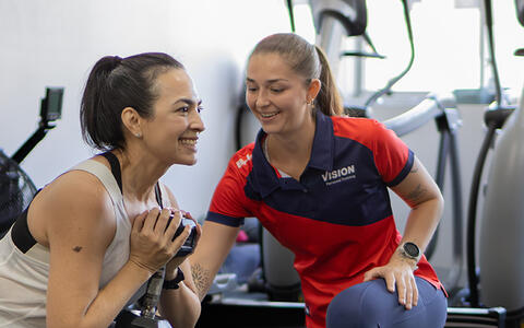 Person supporting women lifting weight