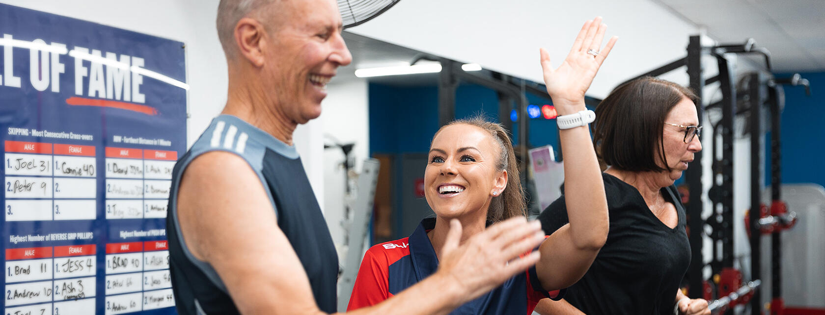 Female trainer with male client and female client in the background